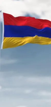 This phone live wallpaper boasts a vibrant digital rendering of a large flag with red, yellow, and blue colors flying high in the sky