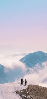 This breathtaking phone live wallpaper features a romantic scene of two people standing on the peak of a snow-covered mountain, surrounded by fluffy clouds in pastel colors