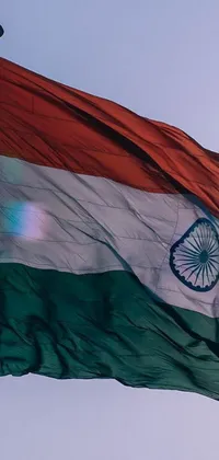 This live wallpaper features the Indian flag billowing in a bright summer sky, highlighted by a sparkling sun