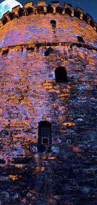 This live phone wallpaper features a tower with a full moon in the background, a medieval queen's portrait, flickr effect, 3 color print, panoramic view, castle wall, and molten lava flowing down the tower's sides