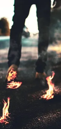 This phone live wallpaper is a unique and eye-catching design featuring fire on the ground as a person walks down a street