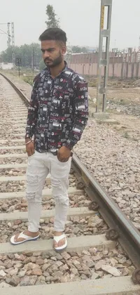 This striking phone live wallpaper features an adventurous man standing on a train track, sporting ripped clothing and a sophisticated block print