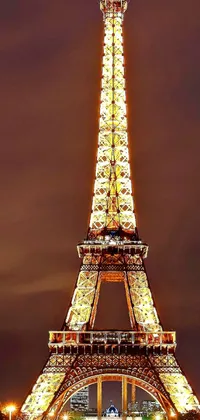 This phone live wallpaper beautifully showcases the Eiffel Tower at night, with a warm glow emanating from the bright lights, creating an enchanting ambiance