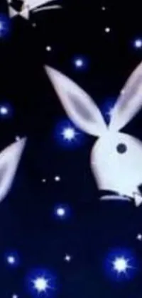 This phone live wallpaper features two adorable white rabbits sitting on a bed with stars scattered around