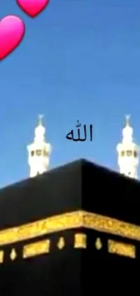 This mobile live wallpaper showcases an image of the Ka'bah or Kabah, a venerated islamic shrine, set against a tower backdrop
