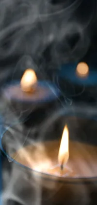 Experience the soothing serenity of a trio of lit candles in this stunning phone live wallpaper