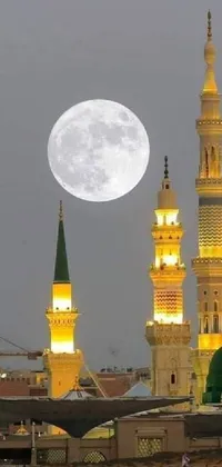 This stunning phone live wallpaper depicts a group of people in front of a large moon and a beautiful picture of a hurufiyya filled with idyllic mosques and greenery in the background