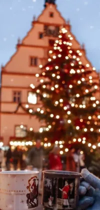 Get in the Christmas spirit with this phone live wallpaper featuring a stunningly decorated tree surrounded by a town square