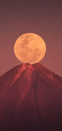 This phone live wallpaper showcases a stunning image of a full moon rising above a mountain against the backdrop of a volcano