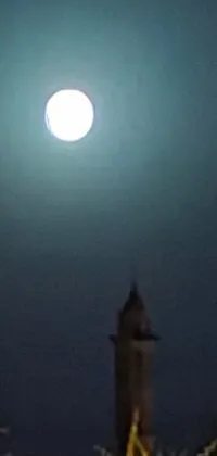 This phone live wallpaper features a breathtaking clock tower set against a full moon background