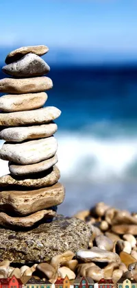 Looking for a serene and calming phone live wallpaper? This minimalistic and mediterranean-inspired design features a pile of rocks sitting on top of a sandy beach, reminding us of the strength and resilience of both nature and the human spirit