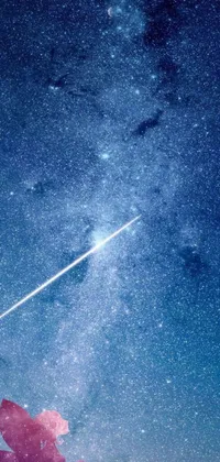 Looking for a live wallpaper that combines the beauty of space with stunning artwork? Look no further than this blue v2 rocket in space! This incredible scene shows a person standing on a hill under a sky full of shining stars, with a rocket in the distance and a meteor streaking across the foreground