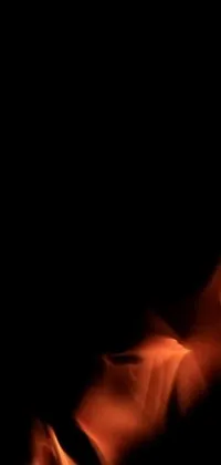 This phone live wallpaper features a blurry image of a fire in the dark