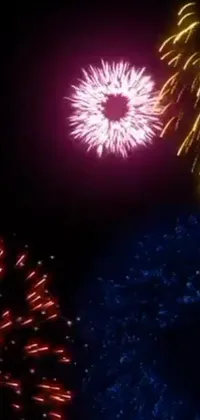 Looking for a stunning live wallpaper to add some excitement to your phone? Look no further than this mesmerizing display of fireworks! With bold red, yellow, and blue colors accenting the night sky, this highly detailed 8k video art is sure to impress