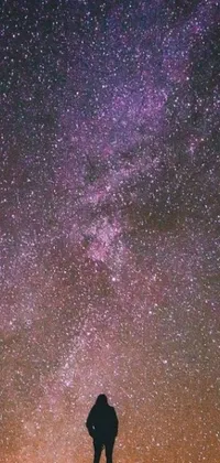 This live phone wallpaper features a breathtaking cosmic purple sky filled with twinkling stars