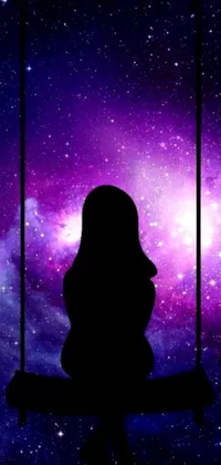 This phone live wallpaper features a stunning silhouette of a person sitting on a swing against a gorgeous outer space nebula background