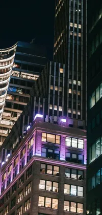 This phone live wallpaper showcases a group of tall, modern buildings, lit up at night on Madison Avenue