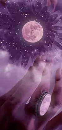 This phone live wallpaper showcases a stunning piece of digital art, featuring a close-up of a hand holding a beautiful flower against a mystical, moonlit purple sky
