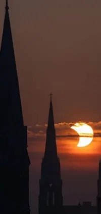 This live phone wallpaper depicts a sunset behind a church with steeples