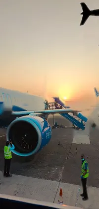 This phone live wallpaper features an awe-inspiring image of a large jetliner parked on an airport tarmac, against a beautiful blue sunset captured in Cambodia