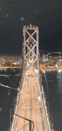 This live wallpaper depicts a long bridge at night, towering over a body of water