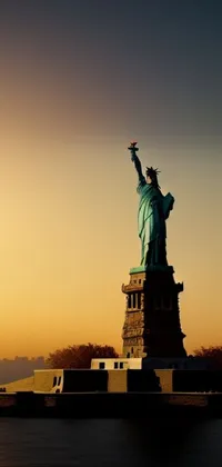 Get the Statue of Liberty with her stunning silhouette set against a sunset for your phone background with this live wallpaper