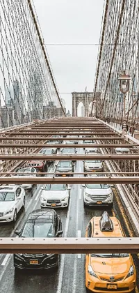 This live wallpaper features a symmetrical image of many colorful vehicles moving and parking on a bridge in New York City, captured in a wide-angle and bird's eye view perspective
