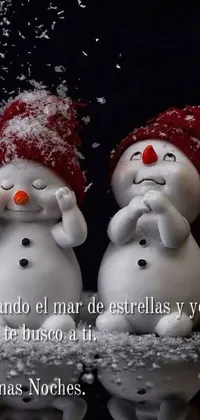 This phone live wallpaper depicts two snowmen standing in front of an idyllic winter wonderland