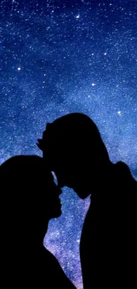 This live wallpaper features a beautiful and romantic silhouette of a couple kissing in front of a stunning night sky design