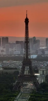 Looking for a stunning live wallpaper to beautify your phone? Check out this amazing view of the Eiffel Tower from the top with an enchanting sunset backdrop, showcasing the mesmerizing urban skyline of Paris