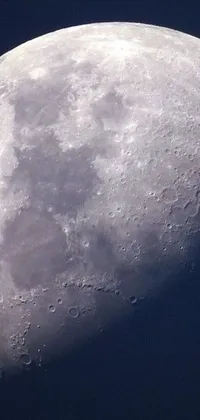 This stunning live wallpaper features a close-up of a detailed macro photograph of the moon with a blue sky in the background