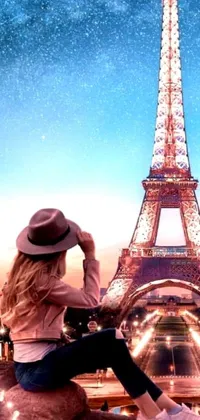 This Eiffel Tower-themed phone wallpaper is a breathtaking digital art creation that features a captivating scene of a blond woman sitting on a ledge