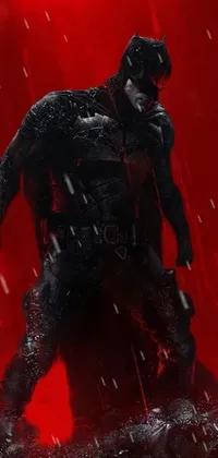 This live wallpaper features a dramatic depiction of the comic book superhero Batman standing in the pouring rain against a vibrant red backdrop