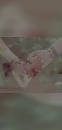 Get this stunning phone live wallpaper featuring a hand holding image in a tinted vintage style