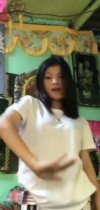 This live wallpaper showcases a room where a young Himalayan woman poses surrounded by pictures on a wall