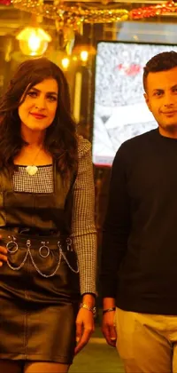 This live wallpaper features a couple in studded leather clothing, posing for a picture at a restaurant