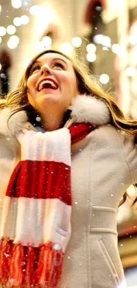 This dynamic phone live wallpaper features a happy woman wearing a white coat and a red and white scarf, holding a phone in her hands