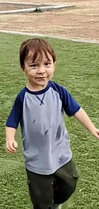 This lively phone live wallpaper showcases a little boy playing with a frisbee in a grassy field, creating an idyllic outdoor scene