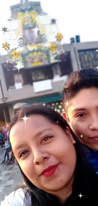 This live wallpaper shows a couple taking a selfie in front of a beautiful building