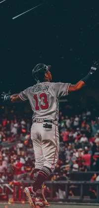This phone live wallpaper brings the spirit of baseball to your device with a player holding a bat on top of a green field, set against a vivid sunset skyline