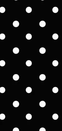 This phone live wallpaper features a chic black and white aesthetic with a playful polka dot pattern on a black background
