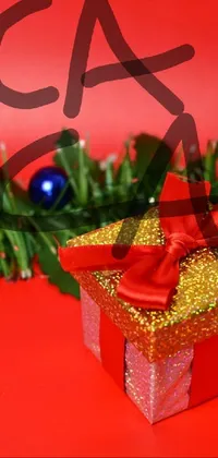 This mobile live wallpaper showcases two beautifully decorated gift boxes, placed on a rich red table with a golden ribbon
