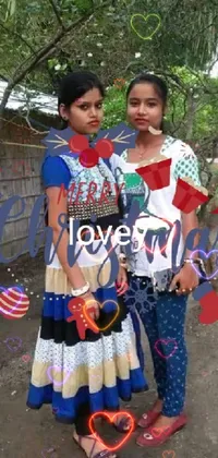 This phone live wallpaper features two women standing together in a festive Assamese setting with a Christmas theme