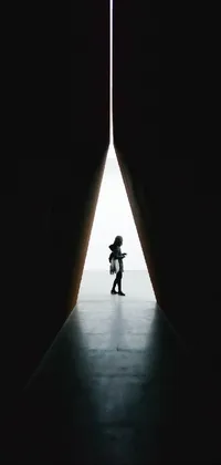 This live phone wallpaper showcases an intriguing silhouette journeying towards a gleaming light at the end of a tunnel