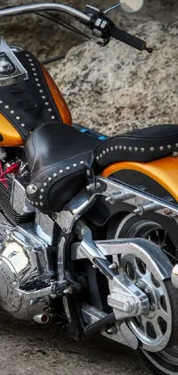 This live wallpaper showcases a photorealistic black and orange motorcycle parked on the side of a road