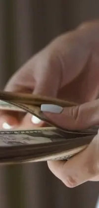 This live wallpaper reflects a photorealistic image of a wallet being held by a hand
