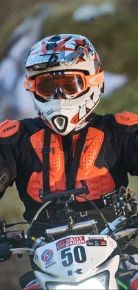 If you're looking for an adrenaline pumping live wallpaper for your phone, check out this one! This action-packed image depicts a dirt bike rider in the middle of a race, captured in a close-up portrait that shows off the rider's glowing eyes through their helmet