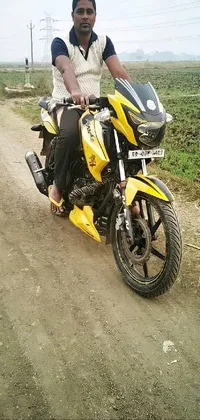 This phone live wallpaper features a vibrant scene of a man riding a yellow motorcycle down a dirt road
