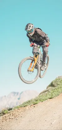 This dynamic live wallpaper features a thrilling image of a man on a bike soaring through the air