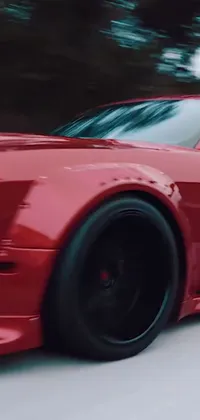 This live wallpaper showcases a red sports car in ultra-detail, with a wide body that drives down a winding road